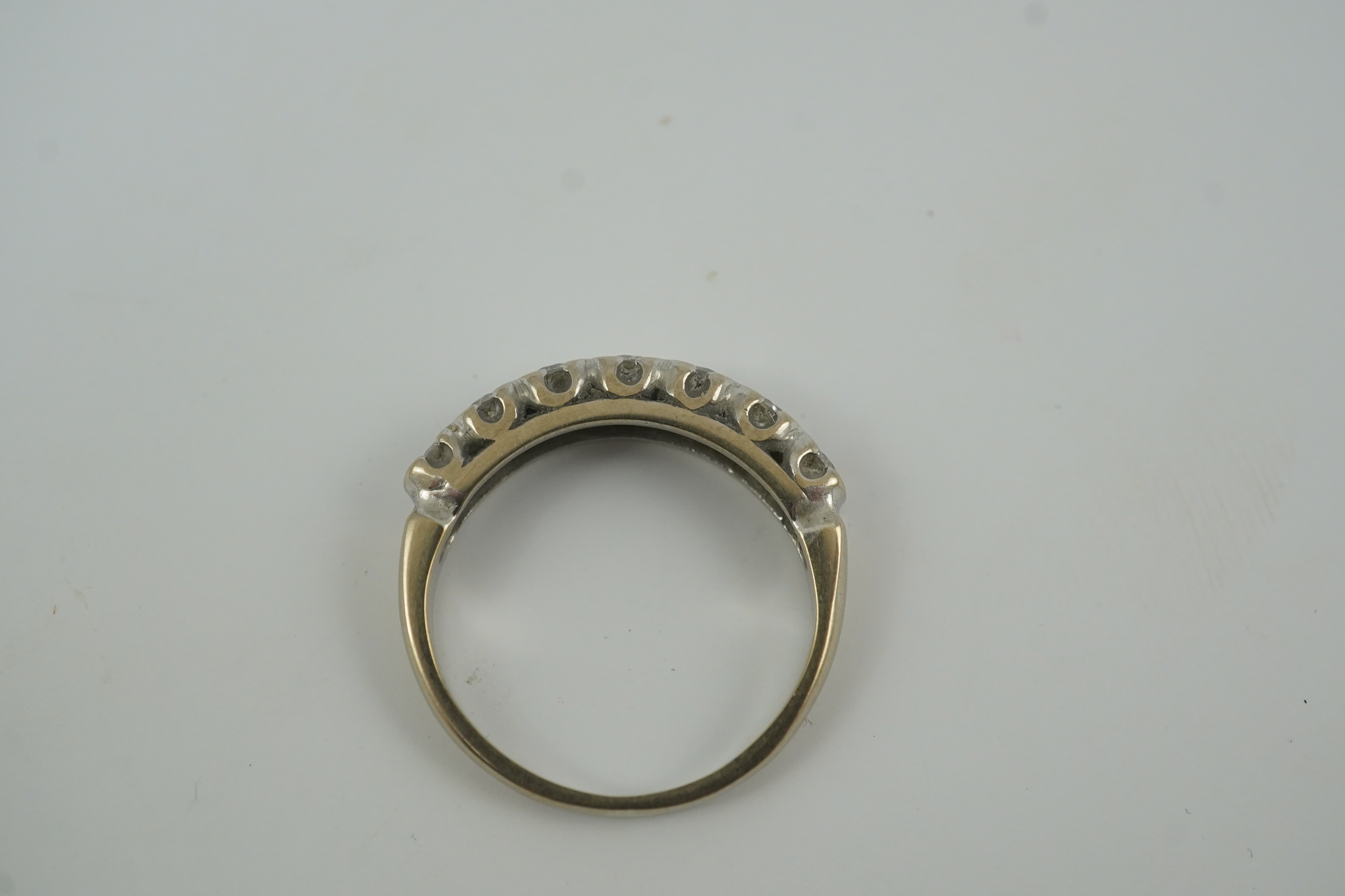 A modern 18ct white gold and graduated seven stone diamond set half hoop ring